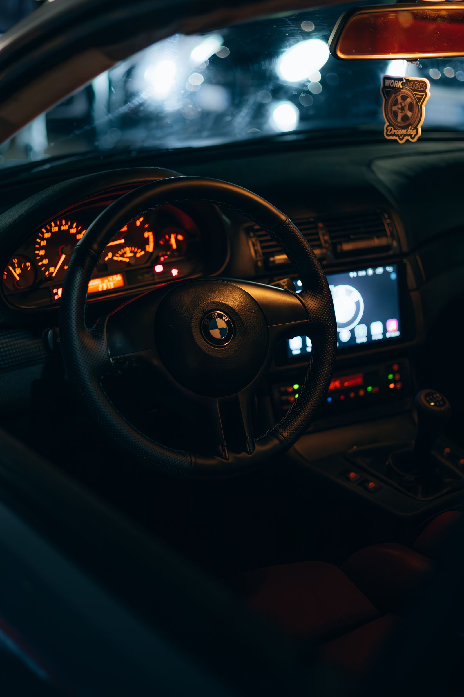 A car cabin lit by its instrument cluster at night